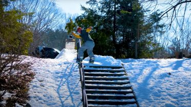 Snowboarder Joe McEvoy front boarding a hand rail