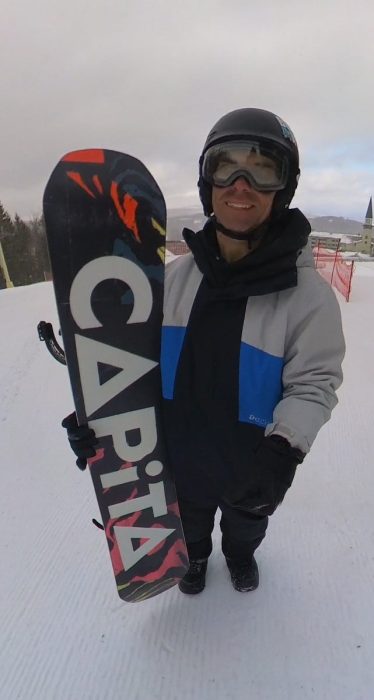 Steve holding the 2025 - 2026 Capita DOA